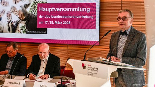 Ein Mann in Anzug steht an einem Rednerpult.