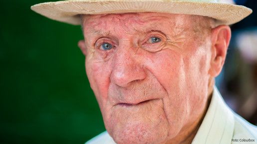 Very old man portrait with emotions. Grandfather happy and smiling. Portrait: aged, elderly senior. Close-up of a pensive old man in white hat sitting alone outdoors at summer.