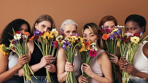 Eine Gruppe diverser Frauen halten Blumensträuße in der Hand