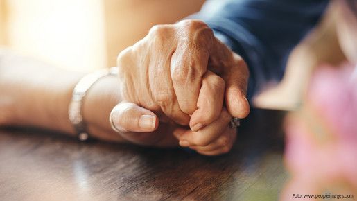 Zwei berührende Hände auf einem Tisch